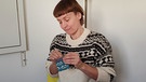Dr. Alexandra Achenbach näht einen Taschenwärmer aus einem alten Socken | Bild: BR/Dr. Alexandra Achenbach