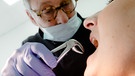 Frau bei Zahnarzt, der eine Zange in der Hand hält | Bild: picture allianc / dpa-tmn / Markus Scholz