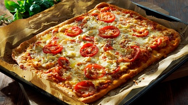 Selbst gemachte Pizza Margherita auf einem Backblech mit Backpapier | Bild: mauritius images / Vi Sin / Alamy