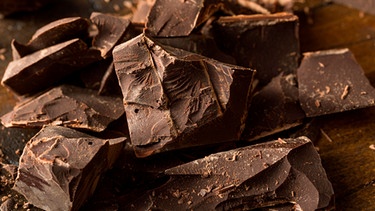 Dicke Schokoladenstücke auf einem Holzbrett | Bild: mauritius images / Brent Hofacker / Alamy