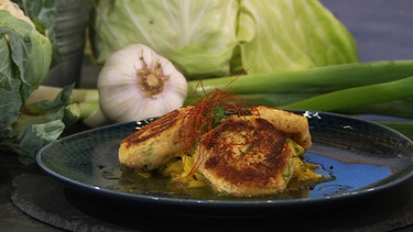 Blumenkohl-Käse-Pflanzerl mit Currykraut auf einem Teller serviert | Bild: BR