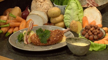 Gebackenes Schweinekotelett mit Erdapfelstampf und Krautsalat | Bild: Wir in Bayern