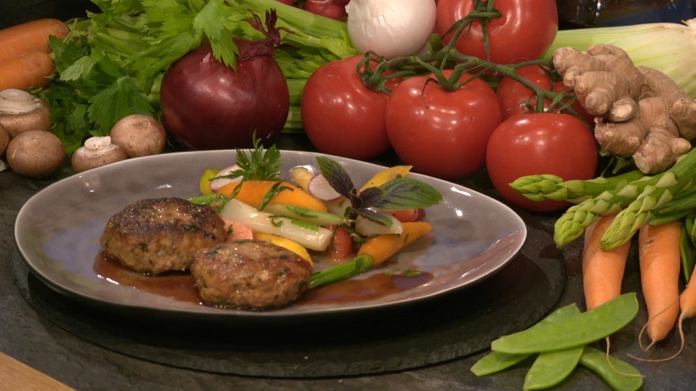 Italienische Fleischpflanzerl mit Frühlingsgemüse auf einem Teller serviert | Bild: BR