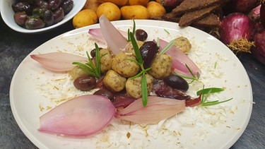 Süßsaure Zwiebeln mit Pumpernickel-Gnocchi auf einem Teller serviert | Bild: BR