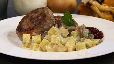 Wildfleischpflanzerl mit Kartoffel-Pilz-Ragout auf einem Teller serviert | Bild: BR