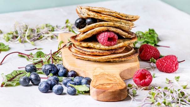 Vegane Kichererbsen-Pancakes mit Beeren auf Brett aus Olivenholz | Bild: mauritius images / foodcollection / Natalia Larina