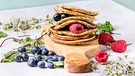 Vegane Kichererbsen-Pancakes mit Beeren auf Brett aus Olivenholz | Bild: mauritius images / foodcollection / Natalia Larina