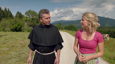 Moderatorin Susanne Wiesner zusammen mit einem Geistlichen in der Sendung "BR Heimat - Zsammg'spuit im Trauntal" | Bild: BR
