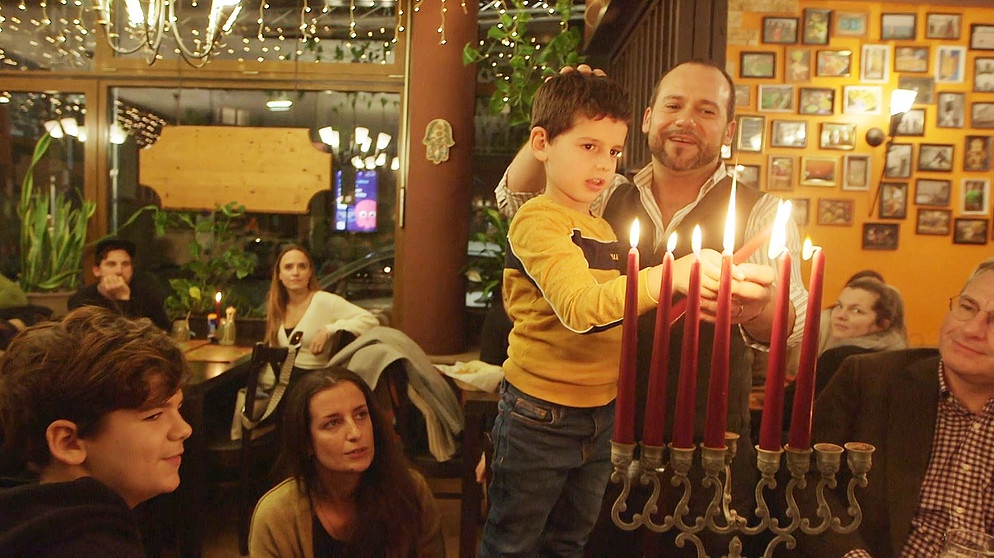 Ben Malenboym und sein Sohn zünden die Kerzen der Channukkia im Restaurant Eclipse Bar an. | Bild: BR