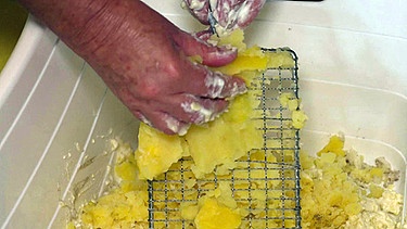 Kartoffeln werden in eine Schüssel gerieben | Bild: BR