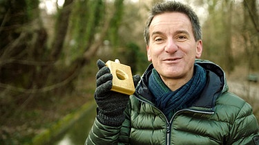 Florian Schrei mit einem Parfumflakon in der Hand | Bild: BR