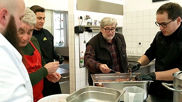 Paul Enghofer darf die Wurstmasse probieren. Links und rechts: der "Kochtrupp" der Feuerwehr in Buxheim im Allgäu | Bild: BR