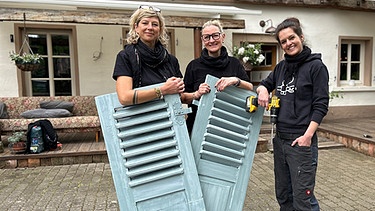 Von links nach rechts: Sabine Pöferlein, Sylvia Pfeiffer und Caro Kreitz mit Fensterläden für den Schnuckenhof | Bild: BR/Ina Schwandner