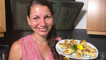 Stefanie Hauner mit frisch gebackenen Blätterteigröllchen mit Spitzwegerich, Löwenzahn und Fetakäse | Bild: BR
