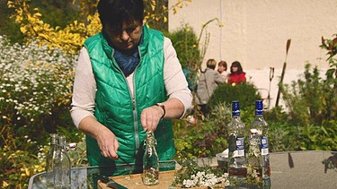Ernestine Kastenmeier beim Befüllen der Schafgarbenlikör-Flaschen. | Bild: BR