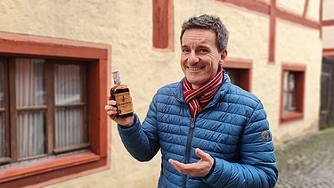 Florian Schrei mit einer Flasche Drachenblut | Bild: Bayerischer Rundfunk