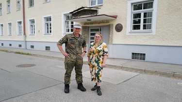 Ein Soldat und eine Frau stehen vor einem Haus | Bild: HR