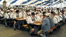 Trachtler sitzen an Tischen im Festzelt. | Bild: picture-alliance/dpa