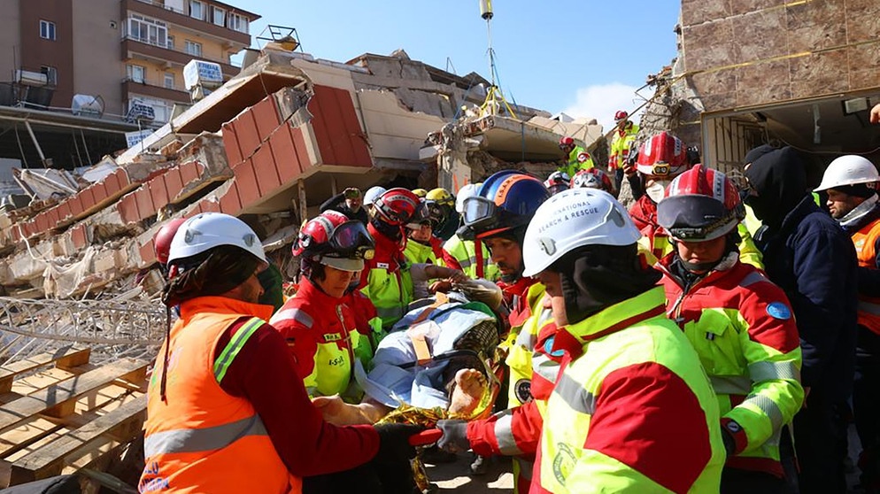 Viele Helfer bergen einen Verletzten aus den Trümmern | Bild: picture-alliance/dpa
