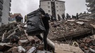 Trümmerhaufen darauf Menschen stehen | Bild: picture-alliance/dpa