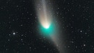 
grün leuchtender Komet mit Sternenhimmel im Hintergrund | Bild: picture-alliance/dpa