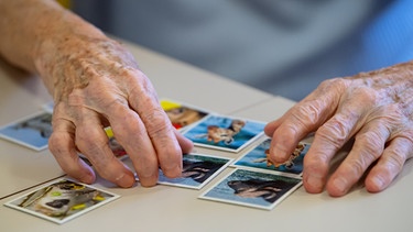 Zwei alte Hände spielen Memory | Bild: picture-alliance/dpa