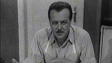 Clemens Wilmenrod war der erste Fernsehkoch im deutschen Fernsehen. Seine Reihe "Bitte in zehn Minuten zu Tisch" mit über 180 Ausgaben lief von 1953 bis 1964, zuerst im NWDR; hier präsentiert er in einer Folge von 1955 Verlorene Eier auf Toast und seine Erfindung "gefüllte Erdbeeren". | Bild: BR/NDR