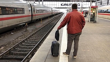 Ein Fahrgast wartet am Bahngleis auf seinen Zug | Bild: BR