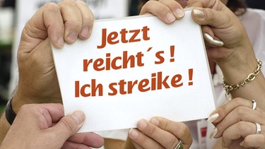 Hände am Schild: "Jetzt reicht_s! Ich streike!". | Bild: picture-alliance/dpa