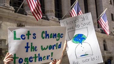 alpha-demokratie - Die USA und der Umweltschutz / Jugendliche mit Plakat vor der New Yorker Börse | Bild: picture-alliance/dpa
