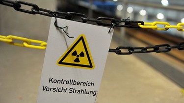 Ein an einer Kette befestigtes Schild im atomaren Zwischenlager in Gorleben warnt vor Strahlung. | Bild: dpa-Bildfunk/Jochen Lübke