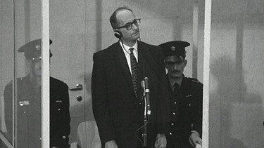 Adolf Eichmann (Mitte) im kugelsicheren Glaskasten mit zwei Polizisten. | Bild: BR
