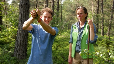 Birgit zeigt Checker Julian die Pflanzen im Moor und was sie alles können. | Bild: BR/megaherz gmbh/Pius Neumaier