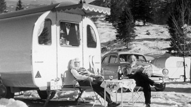 Im tiefsten Winter, wenn der normale Mensch sich bemüht, die Zimmertemperatur auf 20 Grad zu heizen, geben sich in der verschneiten Gebirgslandschaft bei Krün auf dem Campingplatz Tennsee rund 400 Camper ein Stelldichein. Das bedeutet: Morgentoilette im Freien mit kaltem Wasser, Kaffeekochen mit geschmolzenem Schnee, aber auch Schneebar, Liegestühle zum Sonnenbaden, Skifahren am Berg und Schachspielen im Wohnwagen – ein Traum in (Schwarz-)Weiß. | Bild: BR