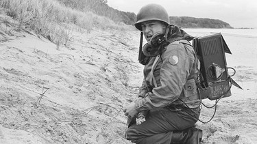 US-Funker Morton Waitzman nach der Landung am Strand (Nachgestellte Szene). | Bild: Yap Films Inc./Stephen Trivieri