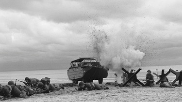 US-amerikanische Soldaten versuchen, von ihrem Amphibien-Landefahrzeug aus den Strand zu überqueren. (Nachgestellte Szene). | Bild: Yap Films Inc./Stephen Trivieri