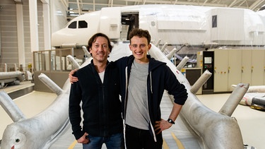 Von Flugsicherheitsexperte Rami lernt Julian (rechts) alles rund um die Sicherheit an Bord eines Flugzeuges. | Bild: BR/megaherz gmbh/Hans-Florian Hopfner
