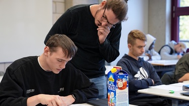 Jonas Jäger (34) hilft einem Schüler während des Unterrichts an der Heinrich-Hübsch-Berufsschule in Karlsruhe. | Bild: SWR