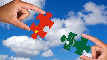 Zwei Hände halten jeweils ein Puzzleteil, China, Afrika | Bild: picture-alliance/dpa