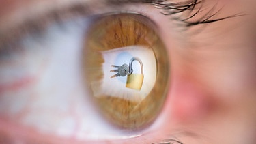 Datensicherheit: Das Bild eines Vorhängeschlosses spiegelt sich im Auge des Betrachters. | Bild: picture-alliance/dpa