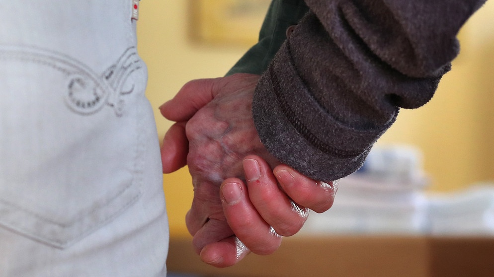 Eine Frau führt eine Bewohnerin der Demenz-Wohngemeinschaft an der Hand. | Bild: dpa-Bildfunk/Karl-Josef Hildenbrand