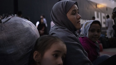Migranten und Flüchtlinge aus dem überfüllten Camp Moria auf Lesbos bei ihrer Ankunft im Hafen von Piräus | Bild: picture alliance / NurPhoto