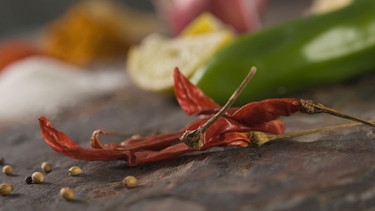 Frische Chilis - Close-up of red chili peppers with coriander seeds | Bild: picture alliance / VisualEyze