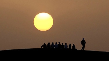 Agnes von Helmolt und ihre Reisegruppe während eines Sonnenuntergangs in der Sahara. Seit 25 Jahren begleitet sie so genannte "Sinnsucher", Menschen auf der Suche nach sich selbst, durch die Wüste. | Bild: BR/Max Kronawitter