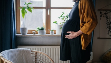 Eine schwangere Frau hält sich den Bauch. | Bild: BR/Julia Müller