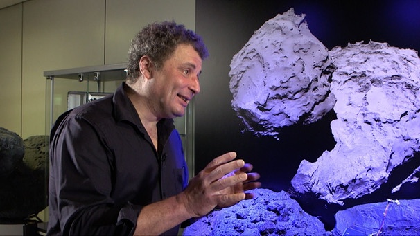 Christian Krause vom Kontrollzentrum der Mascot-Mission vor dem Bild eines Asteroiden, auf dem der Vorgänger-Lander Philae landete. | Bild: BR / Maximilian Schecker