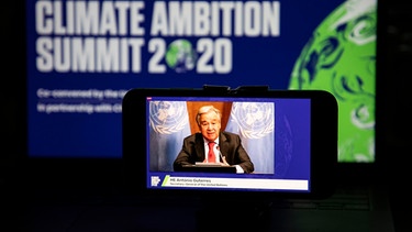 12.12.2020, USA, New York: Das Foto zeigt einen Bildschirm, auf dem UN-Generalsekretär Antonio Guterres per Videolink eine Ansprache an den Climate Ambition Summit 2020 hält. Fünf Jahre nach der Einigung auf das Klimaabkommen der Vereinten Nationen hat UN-Generalsekretär Guterres alle Staaten der Welt aufgefordert, den «Klimanotfall» zu erklären. Foto: Wang Ying/XinHua/dpa +++ dpa-Bildfunk +++ | Bild: dpa-Bildfunk/Wang Ying