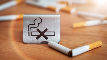 "Rauchen verboten"- Schild neben einer zerbrochenen Zigarette | Bild: picture alliance / CHROMORANGE / Michael Bihlmayer