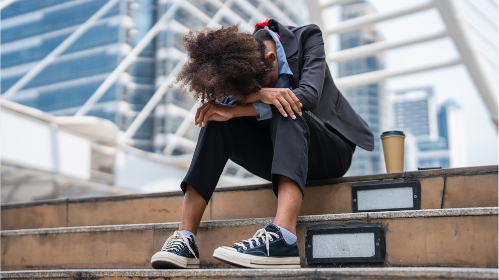 Eine überarbeitete Business-Frau sitzt auf einer Treppe, lässt den Kopf hängen. Ihr denkt ständig an euren Job, arbeitet oft bis tief in die Nacht und könnt auch in eurer Freizeit nur schlecht abschalten? Ihr glaubt, ihr leidet vielleicht unter Arbeitssucht? Das könnt ihr tun, wenn ihr Workaholics seid.    | Bild: Wochit/ Getty Images