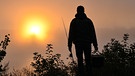 Ein Angler steht im dichten Morgennebel vor dem farbenprächtigen Sonnenaufgang am deutsch-polnischen Grenzfluss Oder. | Bild: picture alliance/dpa/dpa-Zentralbild | Patrick Pleul
